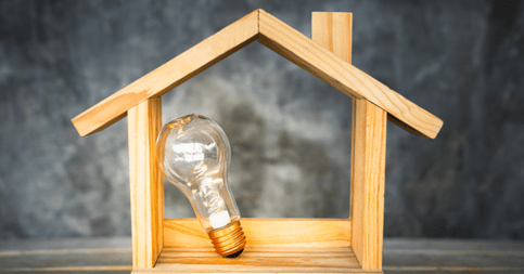 Ampoule posée dans une maquette de maison en bois
