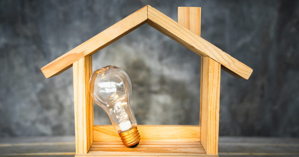 Ampoule posée dans une maquette de maison en bois