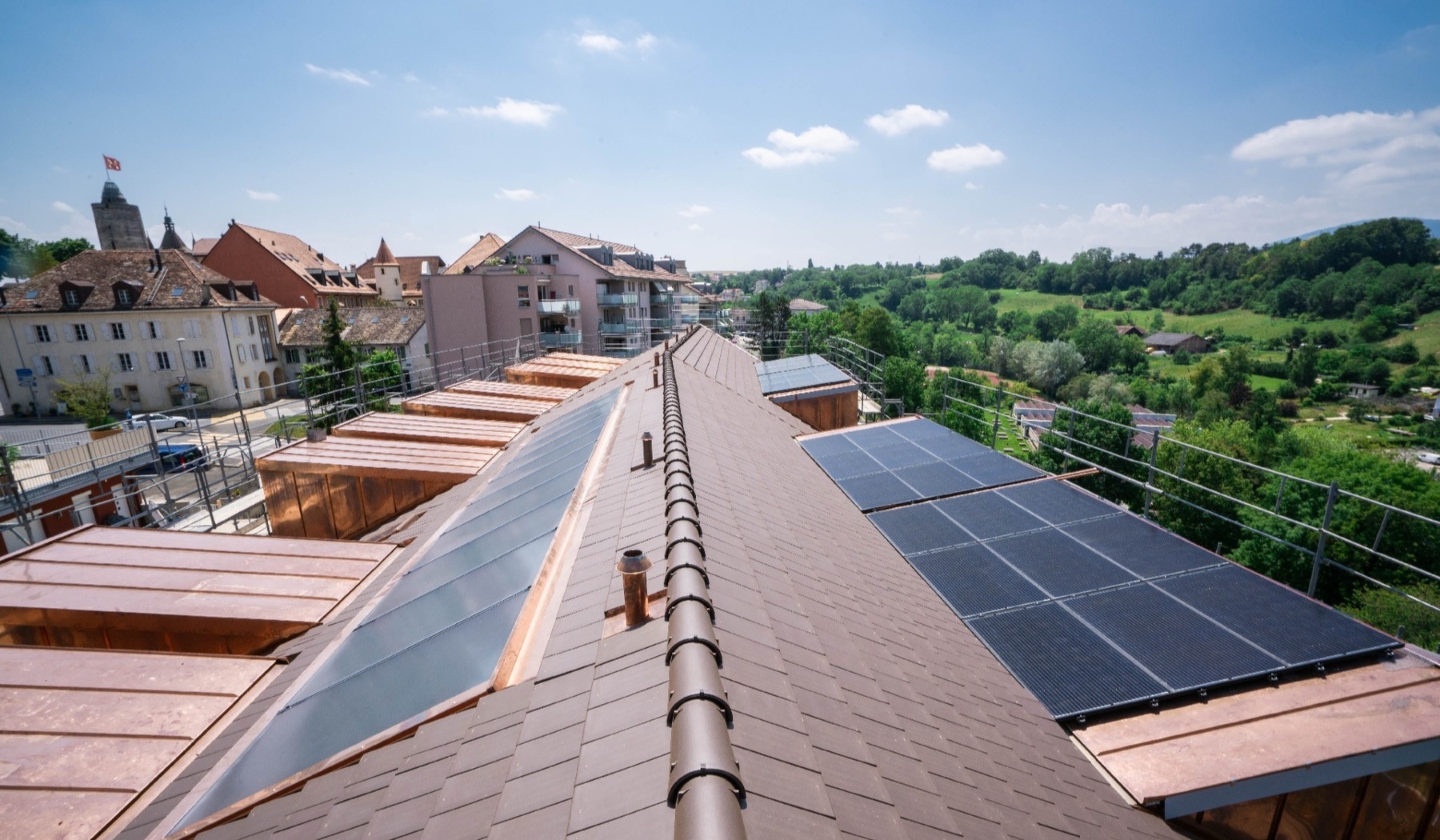Toiture d’un immeuble équipée de panneaux solaires, avec vue sur la ville
